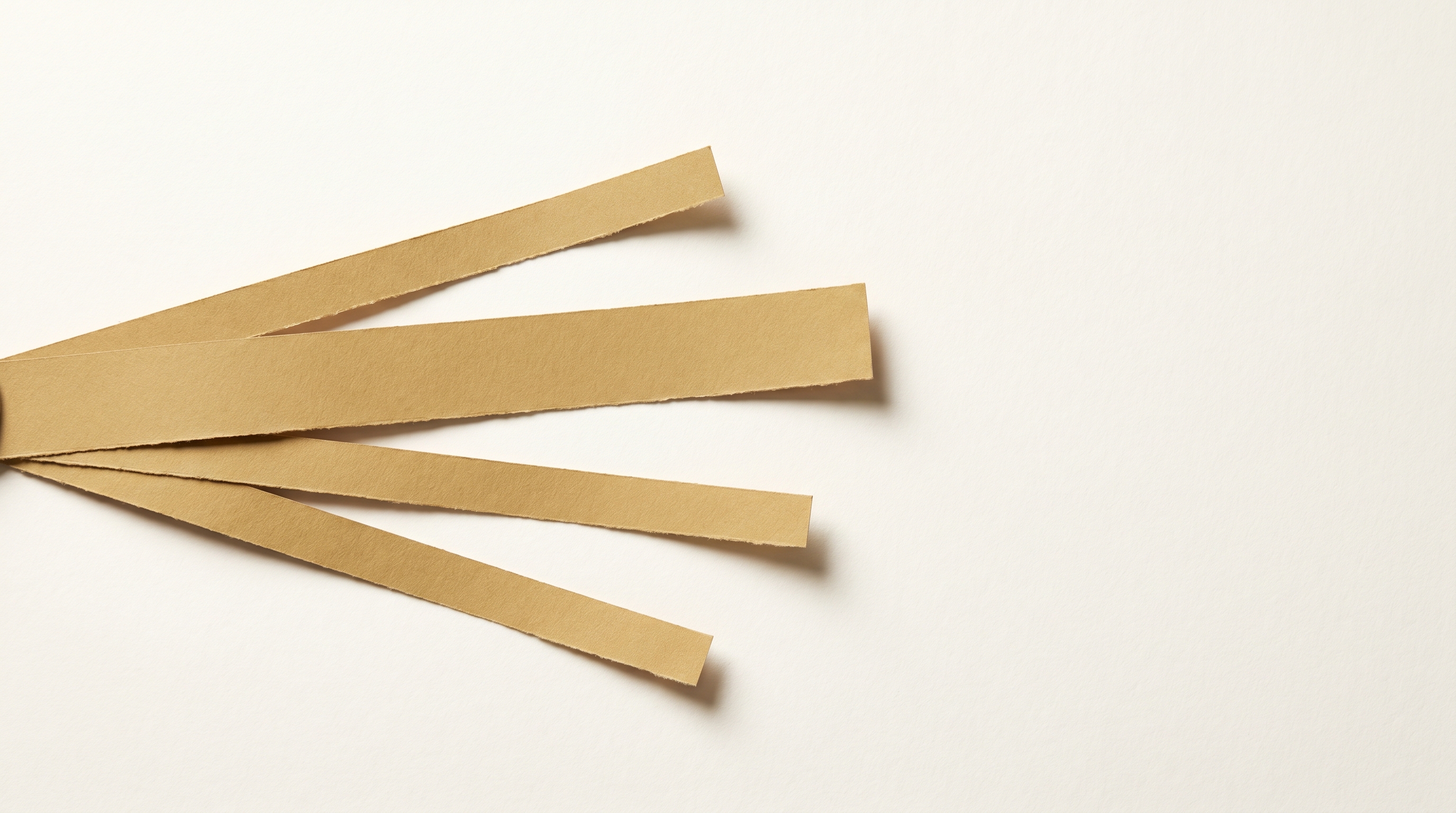 Four muted-gold paper ribbons fanning right from a single starting point — illustrating the choice between marketing channels for healthcare practices